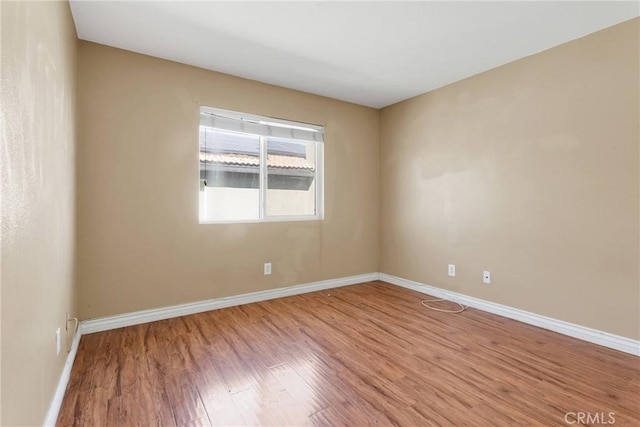 unfurnished room featuring wood finished floors and baseboards