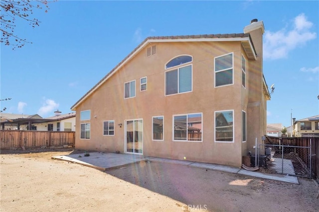 back of property featuring a patio, a chimney, a fenced backyard, and stucco siding