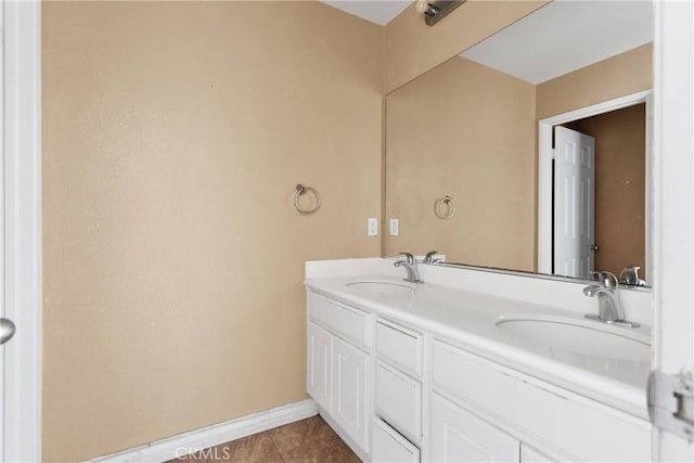 full bathroom featuring tile patterned floors, a sink, baseboards, and double vanity