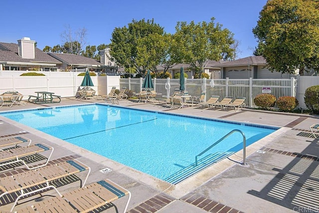 community pool featuring a patio area and fence