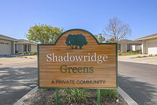 community / neighborhood sign with a garage and concrete driveway