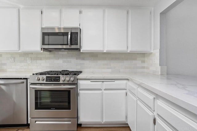 kitchen with white cabinetry, appliances with stainless steel finishes, and tasteful backsplash