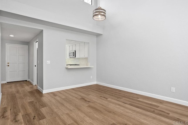 empty room featuring wood finished floors and baseboards