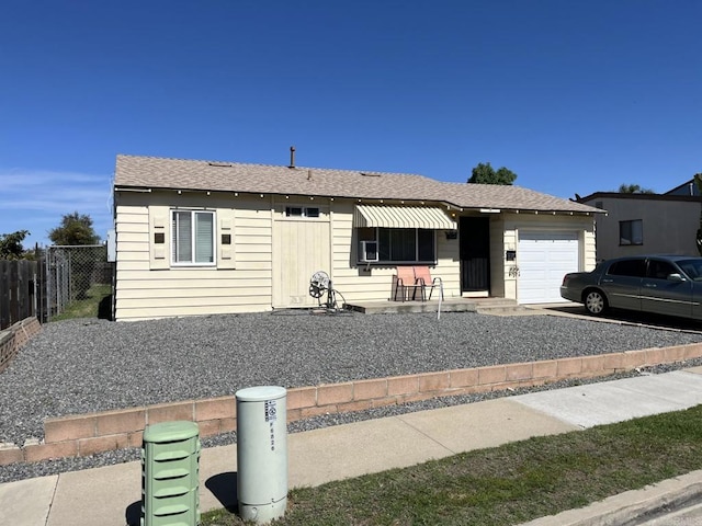 view of front of property featuring roof with shingles, an attached garage, and fence