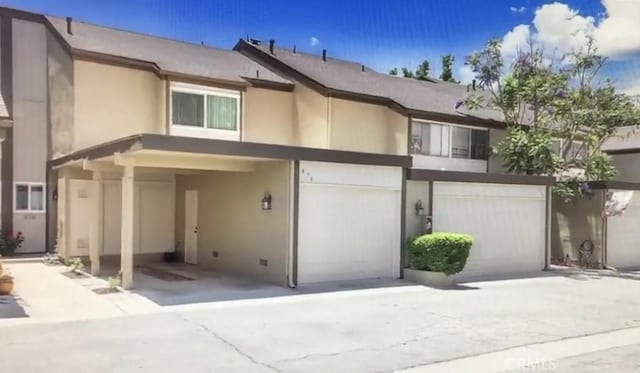 townhome / multi-family property with stucco siding and an attached garage