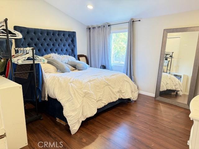 bedroom with recessed lighting, baseboards, lofted ceiling, and wood finished floors