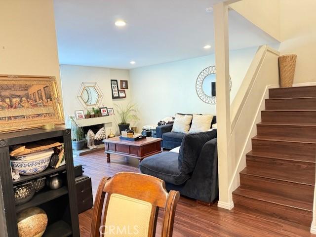 living room with stairs, recessed lighting, and wood finished floors