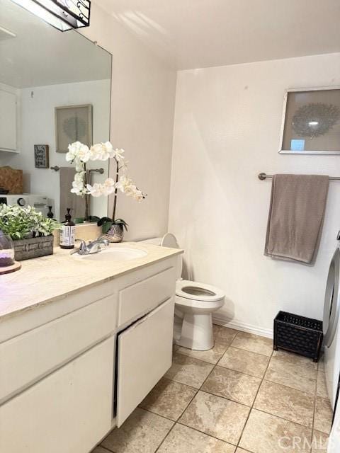 bathroom with toilet, vanity, and tile patterned flooring