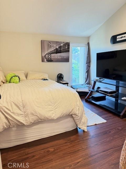 bedroom featuring vaulted ceiling and dark wood-style flooring