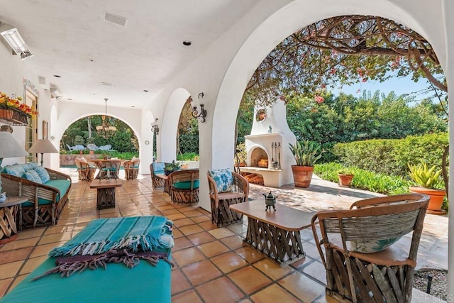 view of patio featuring visible vents, outdoor dining area, and an outdoor living space with a fireplace