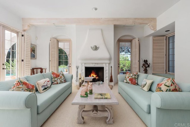 living room featuring beam ceiling and a fireplace