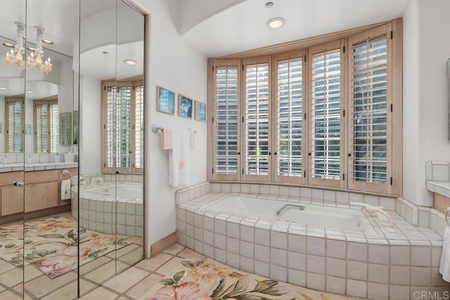 full bath featuring tile patterned floors, a garden tub, and vanity