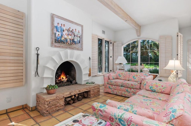 tiled living area with beamed ceiling, visible vents, baseboards, and a lit fireplace