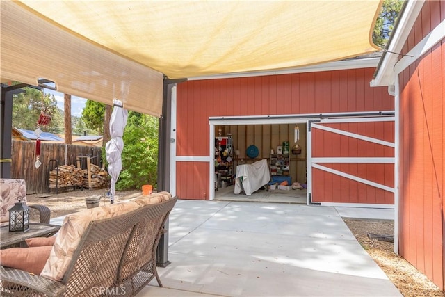 view of patio with an outbuilding and fence