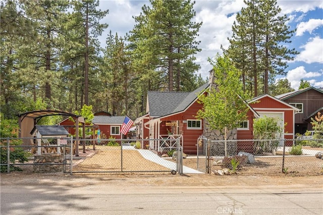 chalet / cabin with a shingled roof, a fenced front yard, and a detached carport