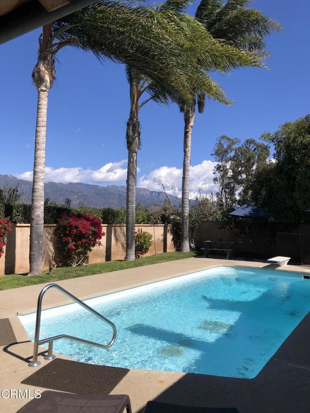 view of swimming pool with a fenced backyard, a mountain view, and a fenced in pool