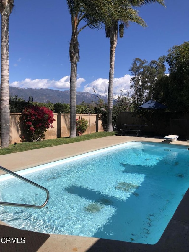 view of swimming pool with a fenced backyard, a mountain view, and a fenced in pool