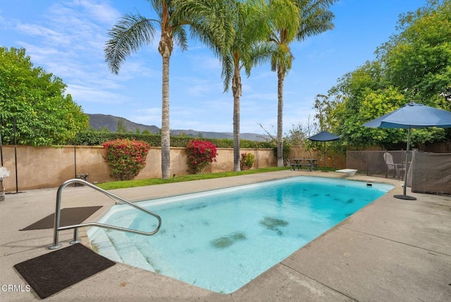 view of swimming pool with a patio area, a fenced backyard, a mountain view, and a fenced in pool