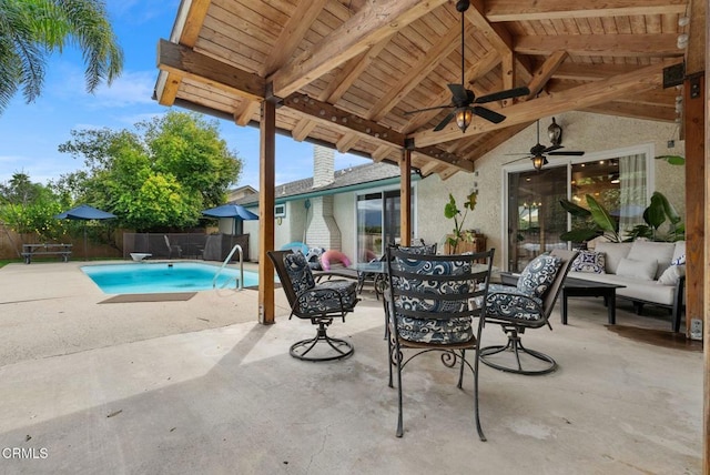 view of swimming pool featuring a fenced in pool, a fenced backyard, ceiling fan, a patio area, and outdoor dining space