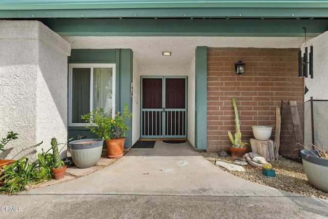 entrance to property with brick siding and stucco siding