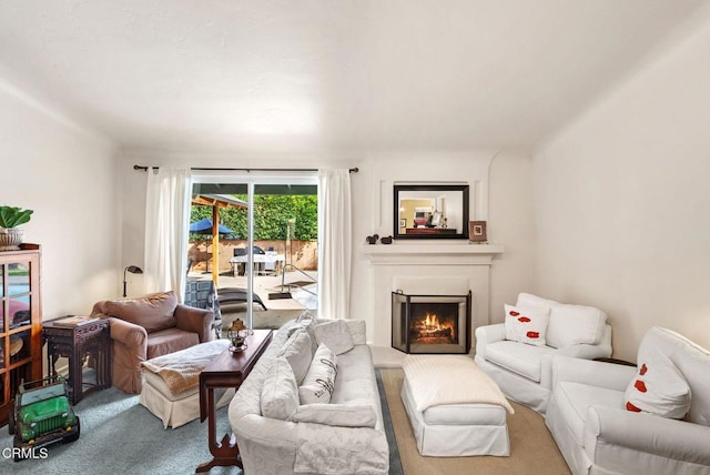 carpeted living room with a lit fireplace