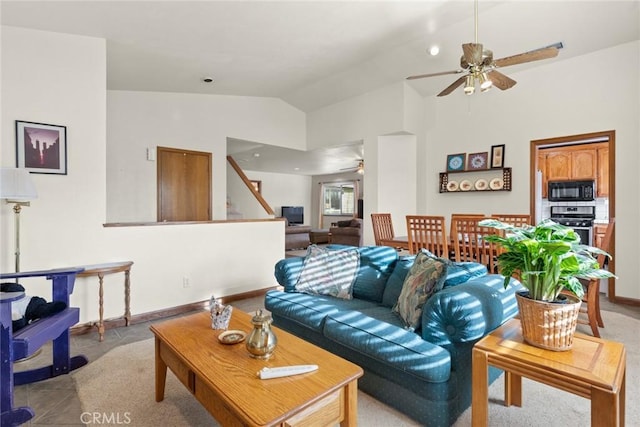 living area featuring baseboards, vaulted ceiling, and a ceiling fan