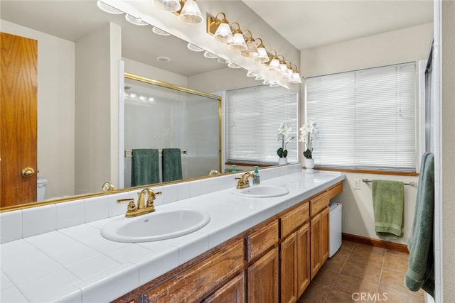 full bathroom with a stall shower, tile patterned flooring, a sink, and double vanity