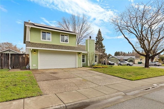 traditional-style home featuring solar panels, fence, concrete driveway, a front lawn, and a chimney