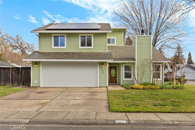 traditional home featuring a shingled roof, fence, driveway, roof mounted solar panels, and a front yard