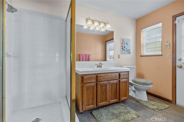 bathroom with a healthy amount of sunlight, a tile shower, vanity, and toilet