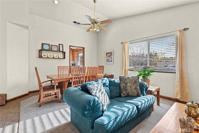 tiled living area featuring lofted ceiling, a ceiling fan, and baseboards