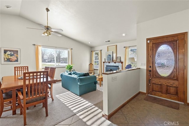 foyer with lofted ceiling, a tile fireplace, visible vents, and tile patterned floors