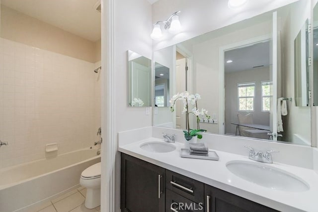 bathroom with toilet, washtub / shower combination, a sink, and tile patterned floors