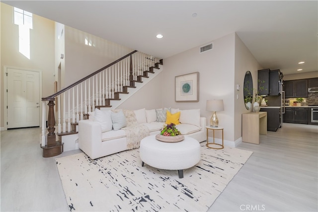 living room with baseboards, visible vents, stairway, light wood-type flooring, and recessed lighting