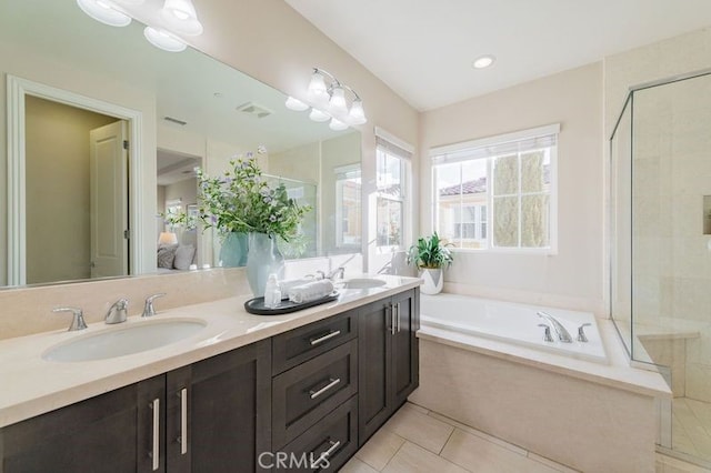 bathroom featuring double vanity, tile patterned floors, a sink, a shower stall, and a bath