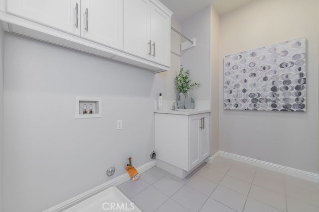 laundry area featuring light tile patterned floors, hookup for a washing machine, cabinet space, gas dryer hookup, and baseboards