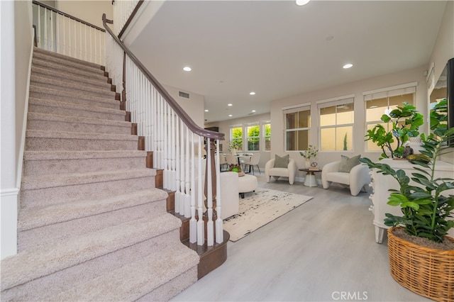 stairway featuring recessed lighting, visible vents, and wood finished floors