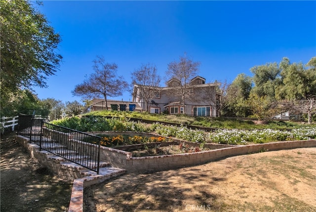 view of front of house with a garden and fence