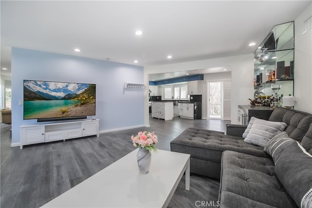 living area featuring bar area, baseboards, dark wood finished floors, and recessed lighting