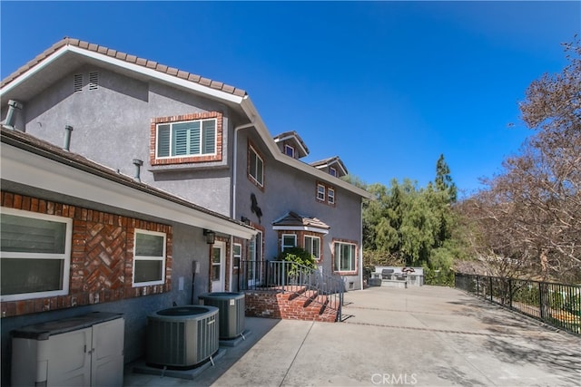 rear view of house featuring central AC, a patio, fence, and stucco siding