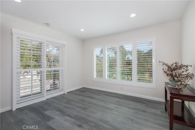 empty room featuring dark wood-type flooring, recessed lighting, and baseboards