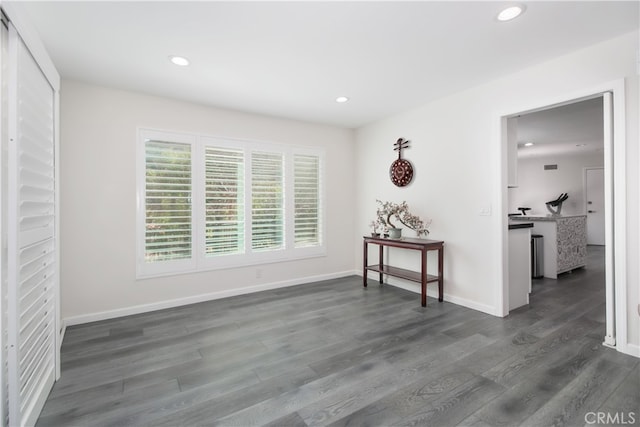 empty room featuring baseboards, dark wood finished floors, and recessed lighting