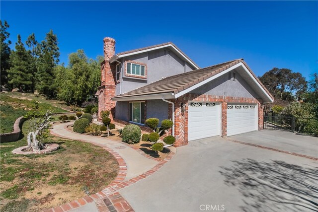 view of property exterior featuring a chimney, stucco siding, fence, a garage, and driveway