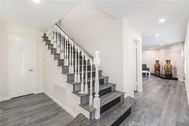 stairway featuring baseboards, wood finished floors, visible vents, and recessed lighting