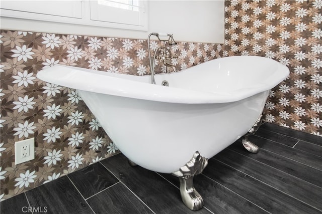 details featuring a freestanding tub and wood finished floors