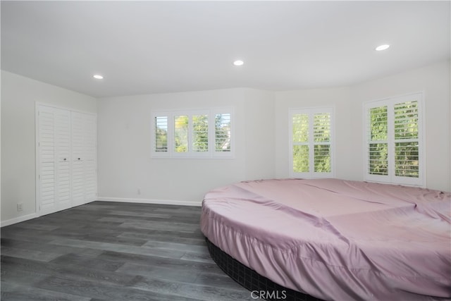 bedroom with dark wood-style floors, multiple windows, and recessed lighting