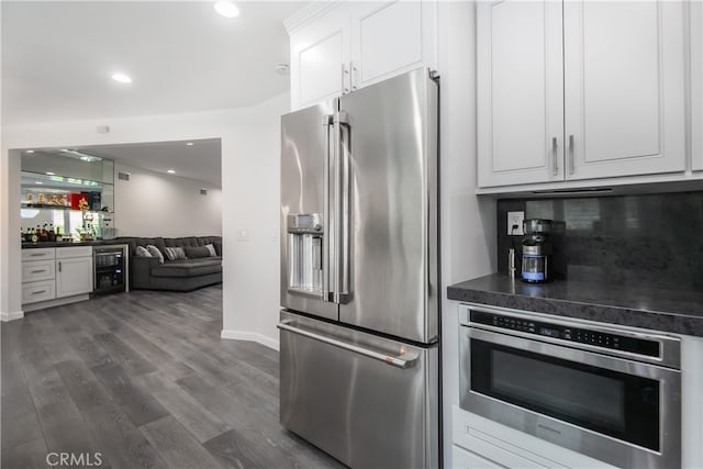 kitchen featuring beverage cooler, white cabinets, high end fridge, dark countertops, and dark wood finished floors