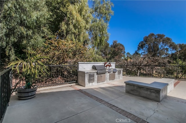 view of patio / terrace with exterior kitchen, area for grilling, and fence