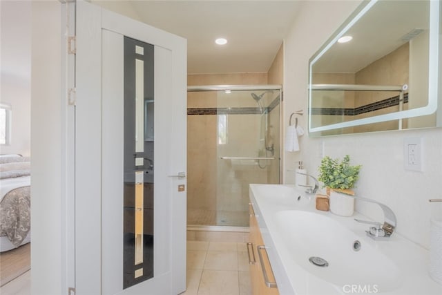 ensuite bathroom with tile patterned flooring, a shower stall, double vanity, ensuite bathroom, and a sink