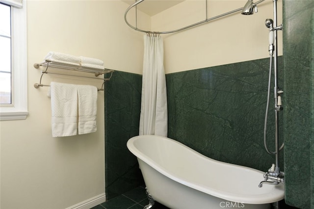 bathroom with tile patterned floors and a freestanding bath